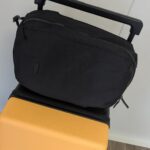Der Rucksack wird sicher auf dem Koffer verstaut